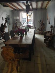 una gran mesa de madera en una habitación con flores. en la maison porte bonheur, en Chantelle 77 fotos más