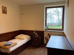 a small room with a bed and a window at Uroczysko Porszewice - Ośrodek Rekolekcyjno-Konferencyjny koło Łodzi in Łódź
