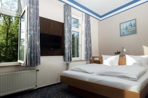 a bedroom with a bed and two windows at Hotel Adler in Waiblingen