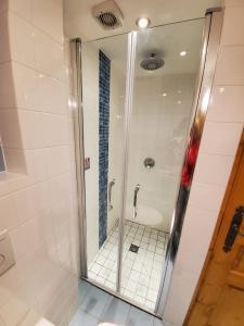 La salle de bains est pourvue d'une douche avec une porte en verre. dans l'établissement Prachtig familie appartement voor 6 personen in het hart van Argentière, Chamonix Mont-Blanc, à Chamonix-Mont-Blanc