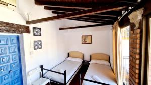 two beds in a small room with a window at Arc House Córdoba Only Adults in Córdoba