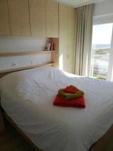ein weißes Bett mit zwei Handtüchern darüber in der Unterkunft IDEAL TOWER DUIN EN ZEE in Blankenberge
