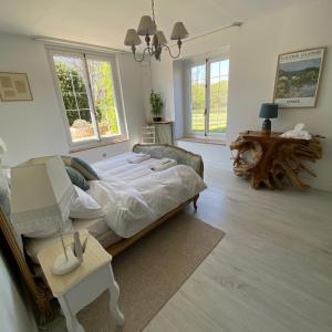 ein Schlafzimmer mit einem großen Bett und einem Tisch in der Unterkunft La Fermette Aux Canards in Savigny-Lévescault