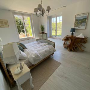 a bedroom with a large bed and a table at La Fermette Aux Canards in Savigny-Lévescault