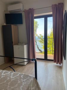 um quarto com uma cama e uma porta de vidro deslizante em Rooms Milena em Senj
