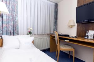 ein Hotelzimmer mit einem Bett und einem Schreibtisch mit einem Computer in der Unterkunft Hotel Adler in Waiblingen