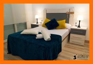 Un dormitorio con una cama grande con almohadas amarillas y azules. en UrbanLux Feria, en Albacete