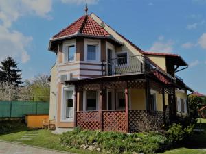 a house with a balcony and a turret at Apartman Mercédesz I. in Zalakaros