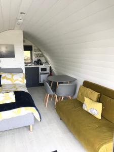 a living room with a couch and a table at Lough Erne Glamping Pod in Enniskillen
