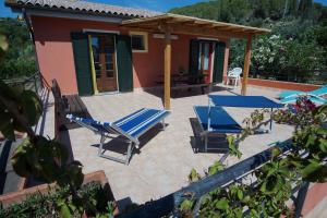 a patio with two lounge chairs and a house at Tenuta Fangati in Portoferraio