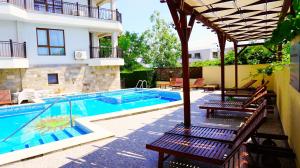 a swimming pool with benches next to a building at Бяла Виста Бийч Апартментс A - Byala Vista Beach Apartments A in Byala +32 photos