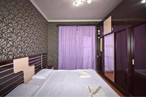 a bedroom with a large bed and a purple wall at Argishti Street, 1 bedroom Modern apartment GL131 in Yerevan