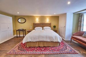 a bedroom with a large bed and a rug at Rook Lane House in Frome