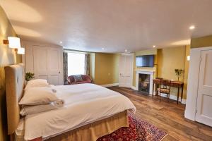 a bedroom with a large bed and a fireplace at Rook Lane House in Frome