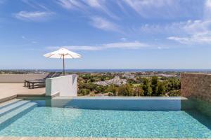 a swimming pool with an umbrella on the roof of a house at Remarkable 2021-Built Luxury Villa in El Herrojo in Benahavís