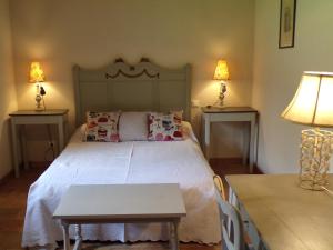 Un dormitorio con una cama con dos mesas y dos lámparas. en Gite Forestier Gentil, en Chanteloup-les-Bois