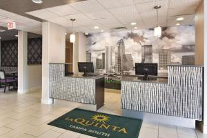 a lobby with a wall mural of a city at La Quinta by Wyndham Tampa Bay Area-Tampa South in Tampa