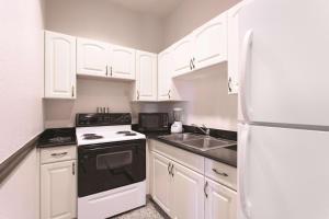 a kitchen with white cabinets and a white refrigerator at La Quinta by Wyndham Tampa Bay Area-Tampa South in Tampa +27 photos