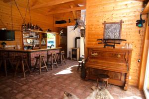 a room with a piano and a bar with stools at Messe-Hotel "Waldruhe" in Giesen