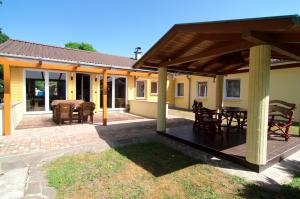 um pátio com uma mesa e cadeiras sob um pavilhão em Messe-Hotel "Waldruhe" em Giesen