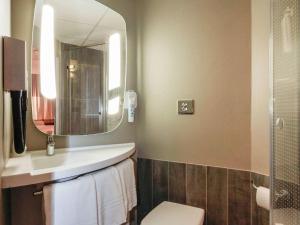 y baño con lavabo y espejo. en ibis Cahors en Cahors