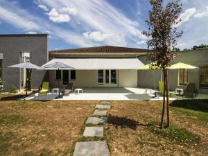 una casa con dos sombrillas y sillas en un patio en ibis Cahors en Cahors