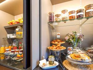 a buffet with plates of food on a counter at Mercure Rennes Centre Place Bretagne in Rennes