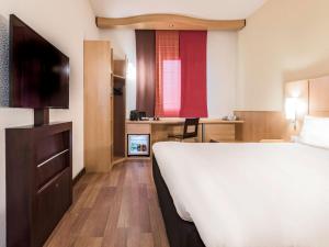 a hotel room with a bed and a desk at Hotel Ibis Milano Malpensa in Cardano al Campo