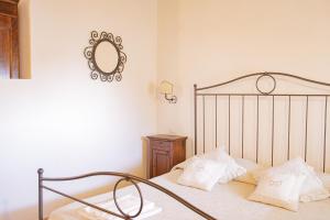 una camera da letto con un letto con cuscini bianchi e uno specchio di Casa AUREA Tre Posti Letto a 30 metri dal Mare a San Vincenzo