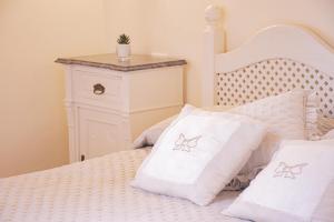 un letto bianco con cuscini bianchi e un tavolino di Casa VELIA 78Mq a 30 metri dal Mare di San Vincenzo a San Vincenzo