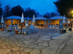 un patio con mesas, sillas y sombrillas por la noche en Posada De Gaspar, en Rabanal del Camino