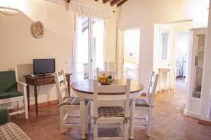 cocina y comedor con mesa y sillas en Casa VELIA 78Mq a 30 metri dal Mare di San Vincenzo, en San Vincenzo