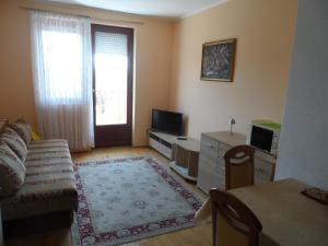 un soggiorno con divano e TV di Apartman Berki a Hévíz