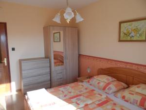 a bedroom with a bed and a dresser at Apartman Berki in Hévíz