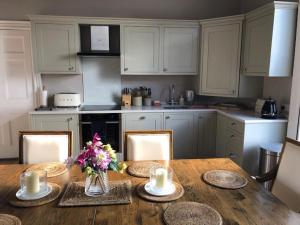 a kitchen with a wooden table with flowers on it at 1 Georges Place Bath in Bath