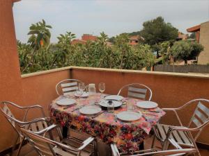 stół z krzesłami i kieliszki do wina na balkonie w obiekcie Ongi Etorri w mieście Calafat