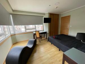 a bedroom with a bed and a table and a desk at Aparthotel Arenteiro in Carballino