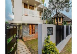 a house with a fence in front of it at MySpace Express Oleander Service Apartments in Madikeri