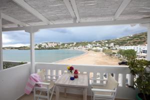 einen Balkon mit einem Tisch und Stühlen sowie einem Strand in der Unterkunft Bella Vista in Batsi