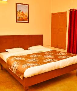Gobind Bhawan Heritage Hotel في حاريدوار: سرير كبير في غرفة نوم مع ستارة حمراء