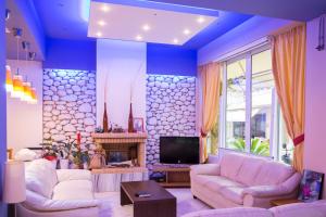 ein Wohnzimmer mit zwei Sofas und einem Fernseher in der Unterkunft Hotel Segas in Loutraki