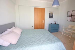 een slaapkamer met een blauw bed en een houten deur bij Apartment near the sea and the Athens airport , Artemida in Artemida