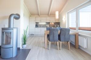 a kitchen and dining room with a table and chairs at Ferienhaus Syltrose in Dagebüll