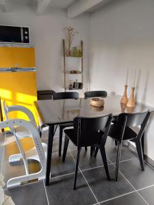 a dining room with a table and chairs at Le petit blanc in De Haan
