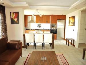 uma cozinha e sala de estar com mesa e cadeiras em Xperia Alanya Park Residence with large balcony and seaview & free airport shuttle service em Alanya