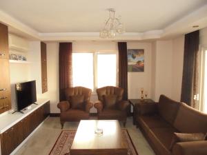 a living room with two couches and a tv at Xperia Alanya Park Residence with large balcony and seaview & free airport shuttle service in Alanya