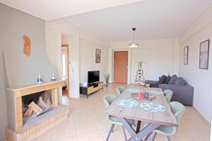 salon ze stołem i kominkiem w obiekcie Apartment near the Athens Airport, Spata w mieście Spata