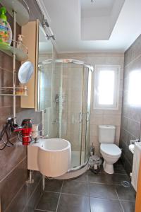 ein Bad mit einer Dusche, einem Waschbecken und einem WC in der Unterkunft Apartment near the Athens Airport, Spata in Spáta