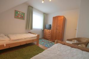 - une chambre avec 2 lits, une télévision et une commode dans l'établissement 1006 - Haus Seesternweg, à Dahme