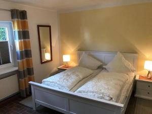 een bed in een slaapkamer met 2 lampen en een spiegel bij 8001 - Sol y Mar in Dahme